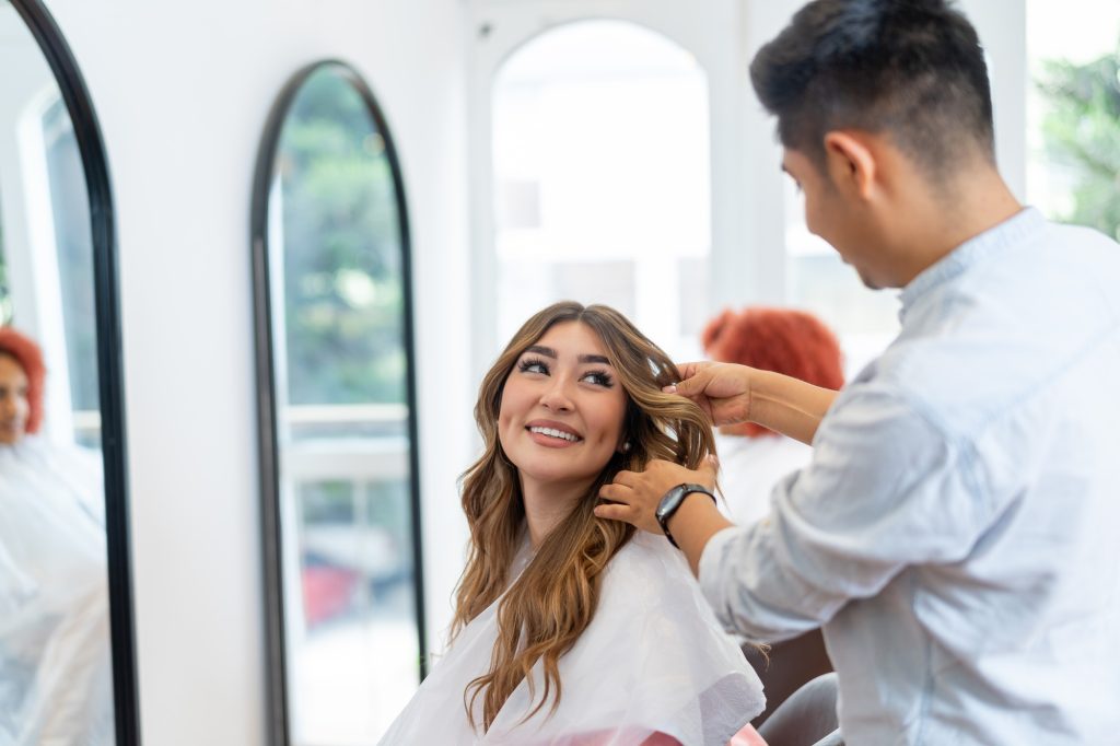 Woman smiling while talking with her hairdresser